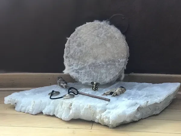 Spiritual tools like drum and Ganesha on stone